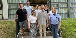 Gruppenfoto mit acht Personen vor einem Gebäude