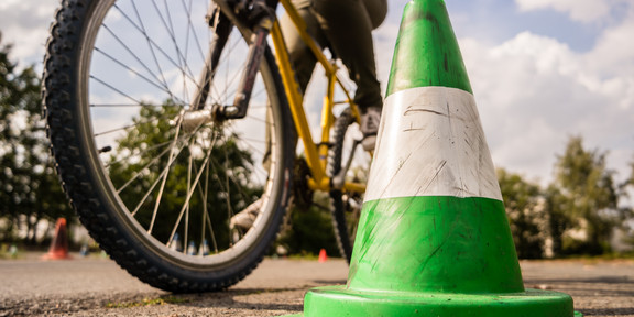 Symbolbild. Fahrrad neben grünen Verkehrskegel.