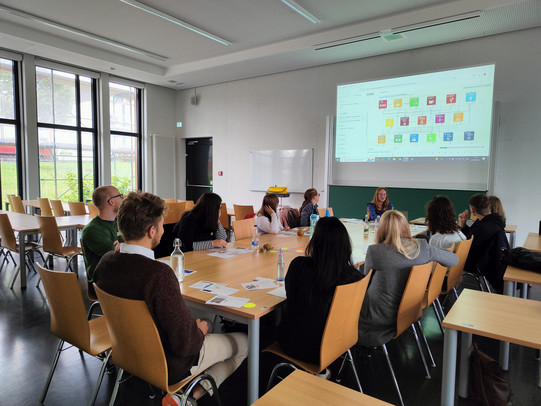 Gruppe spielt gemeinsam ein Planspiel