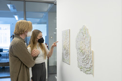 Zwei Besucher*innen betrachten ein dreidimensionales Kunstwerk