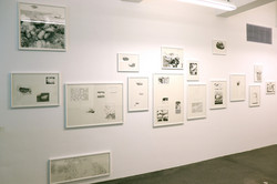 Das Foto zeigt schwarz-weiße Bilder in weißen Rahmen auf einer weißen Wand.