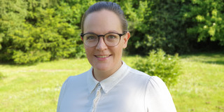 Ein Porträtbild von einer Frau vor einem grünen Baum, die Frau ist Leonie Seebach.