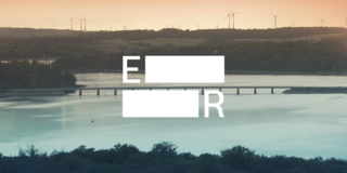 The Evolving Regions logo is centered, with a lake crossed by a bridge and hills with wind turbines in the background at dusk.