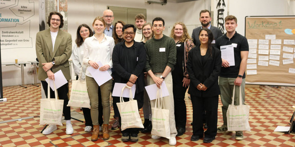 Smash_Abschlussveranstaltung Zu sehen ist das Siegerteam der Smash the Box Challange in einer Halle mit hohen Decken
