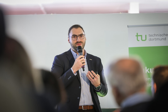 Foto: Eine Person spricht mit Mikrofon.