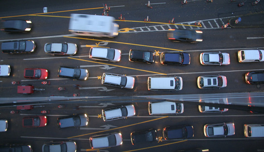 Several cars are shown in a queue from above.