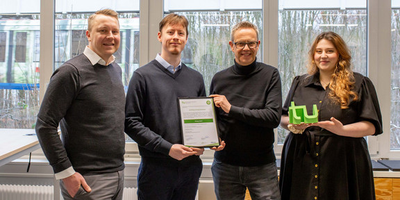 Gruppenfoto: Markus Neuhaus, Kanzler der TU Dortmund, überreicht ein Zertifikat an den Studenten Philipp Stehr. Mit auf dem Foto: CET-Geschäftsführer Dr. Ronald Kriedel und Zertifikatskoordinatorin Dilista Jakupi. 