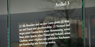 Der Artikel 3 des Grundgesetzes zur Gleichheit von Männern und Frauen steht auf einer Platte aus Glas, aufgenommen am 03.04.2016 in  Berlin im Bezirk Mitte im Regierungsviertel. Nach Artikel 3 darf auch Niemand wegen seiner Rasse, Herkunft oder politischen Anschauungen diskriminiert werden.