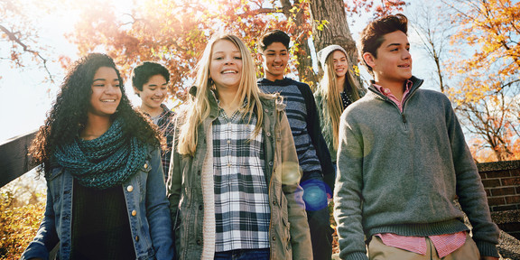 Auf dem Foto sieht man sechs Jugendliche, die lächeln. Im Hintergrund scheint die Sonne.
