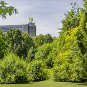 Das Mathematikgebäude mit grünen Bäumen im Vordergrund.