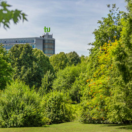 Das Mathematikgebäude mit grünen Bäumen im Vordergrund.