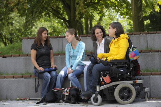 Students with handicap are sitting together on campus.