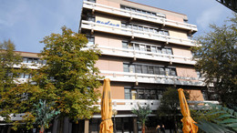 A building with plenty floors surrounded by trees.