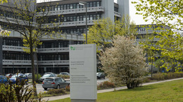 Das Gebäude an der Emil-Figge-Straße 50 mit einer Stele im Vordergrund.