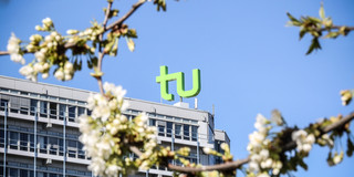 The TU building surrounded by blooming cherry blossoms.
