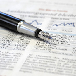 Eine Zeitung mit Informationen zur Börse und ein Füllfederhalter liegt darauf.